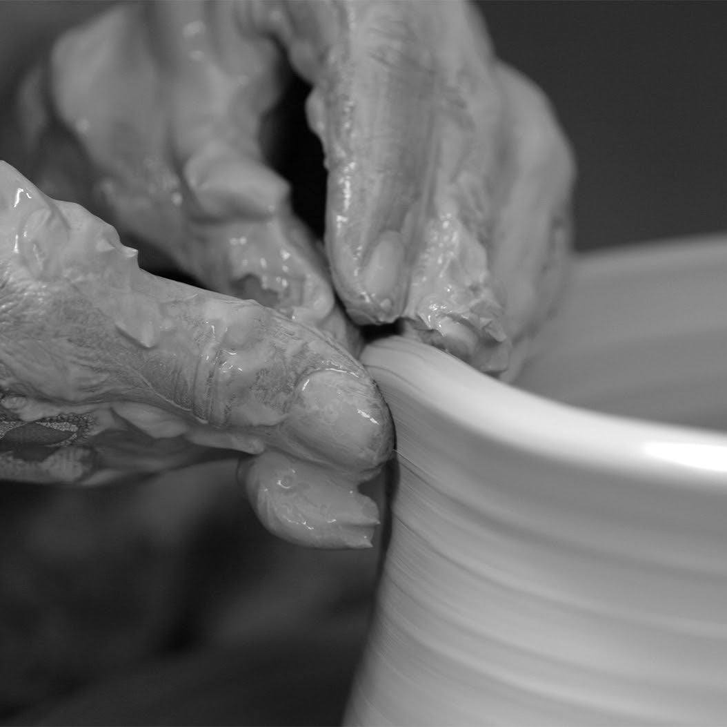 Mains qui façonnent l'argile au tour à poterie